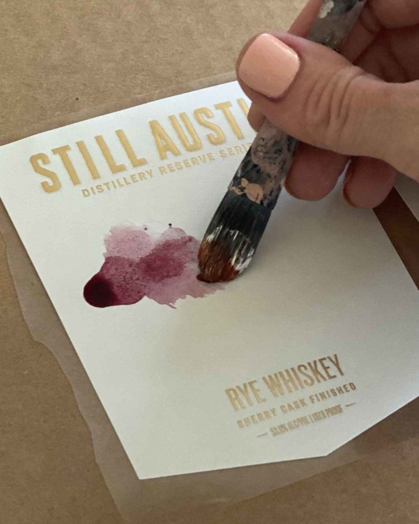 artist Rachel Dickson hand painting labels for still austin whiskey co distillers reserve series sherry cask finished rye